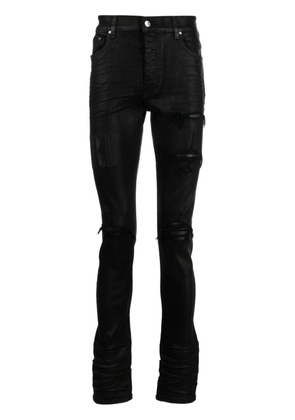 AMIRI logo-embroidered distressed slim-cut jeans - Black