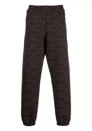 Moschino all-over embroidered logo track pants - Brown