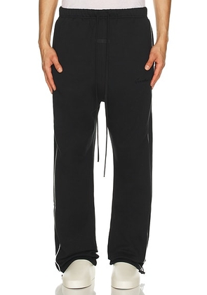 Fear of God ESSENTIALS Sporty Nylon Relaxed Sweatpant With Piping in Jet Black & Cloud White - Black. Size L (also in M, S, XL/1X, XS).