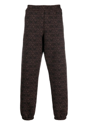 Moschino all-over embroidered logo track pants - Brown
