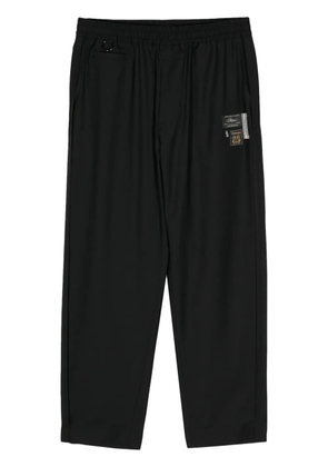 Undercover logo-appliqué straight trousers - Black