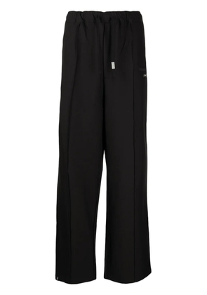 izzue logo-plaque straight-leg trousers - Black