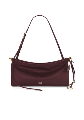 ALAÏA Medium East West Bag Nylon in Rouge Grenat - Wine. Size all.
