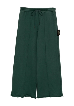 Undercover slogan-patch trousers - Green
