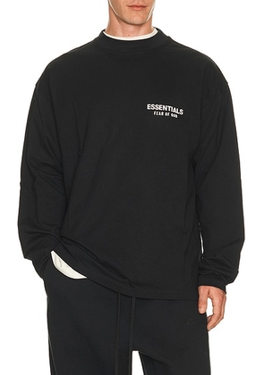 Fear of God ESSENTIALS Classic Fit Long Sleeve T-Shirt in Vintage Black / White in Vintage Black & White - Black. Size L (also in M, S, XL/1X, XS,...