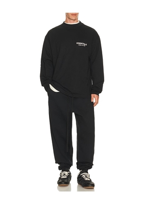 Fear of God ESSENTIALS Classic Fit Long Sleeve T-Shirt in Vintage Black / White in Black. Size L. Also in S, XS, M, XL/1X, XXL/2X.