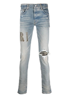 AMIRI logo-print distressed skinny jeans - Blue