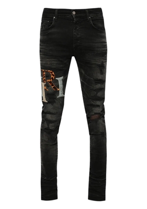 AMIRI logo-patch distressed skinny jeans - Black