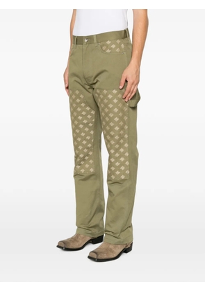 AMIRI monogram-pattern panelled trousers - Green
