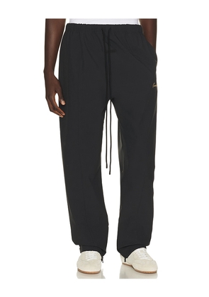 Fear of God ESSENTIALS Signature Track Pant in Black. Size XS. Also in S, M, L, XL/1X, XXL/2X, XXXL/3X.